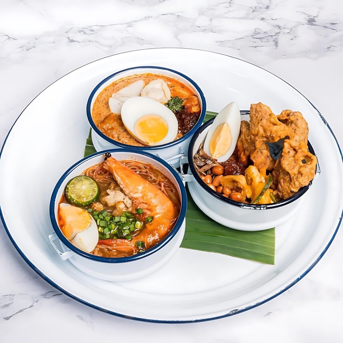 Relive Singaporean classics with The White Tiffin's signature trio - Laksa, Mee Siam, & Nasi Lemak!