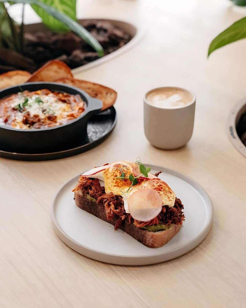 Savour the perfect blend of sweet and savoury with Lola's Cafe's must-try Pulled Pork & Avocado Eggs Benedict!